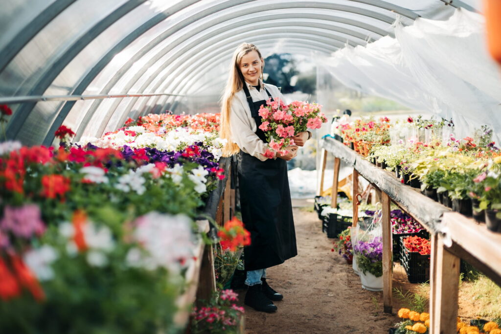 Woman in greenhouse with flower bouquets